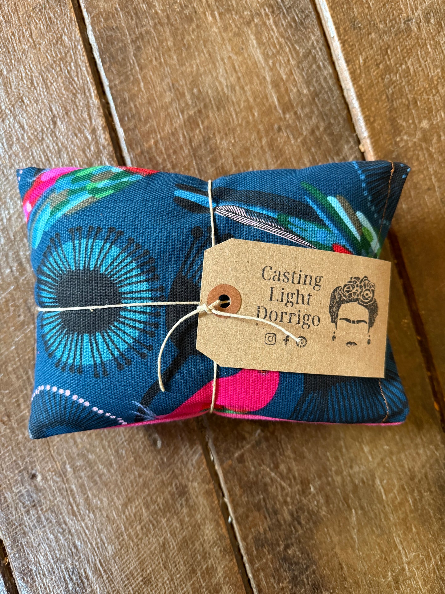 Colorful fabric package with a 'Casting Light Dorrego' tag on a wooden surface