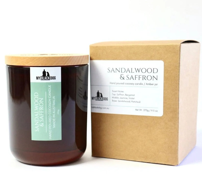 Candle with wooden lid and packaging labeled 'Sandalwood & Saffron' by 'My Black Dog'.