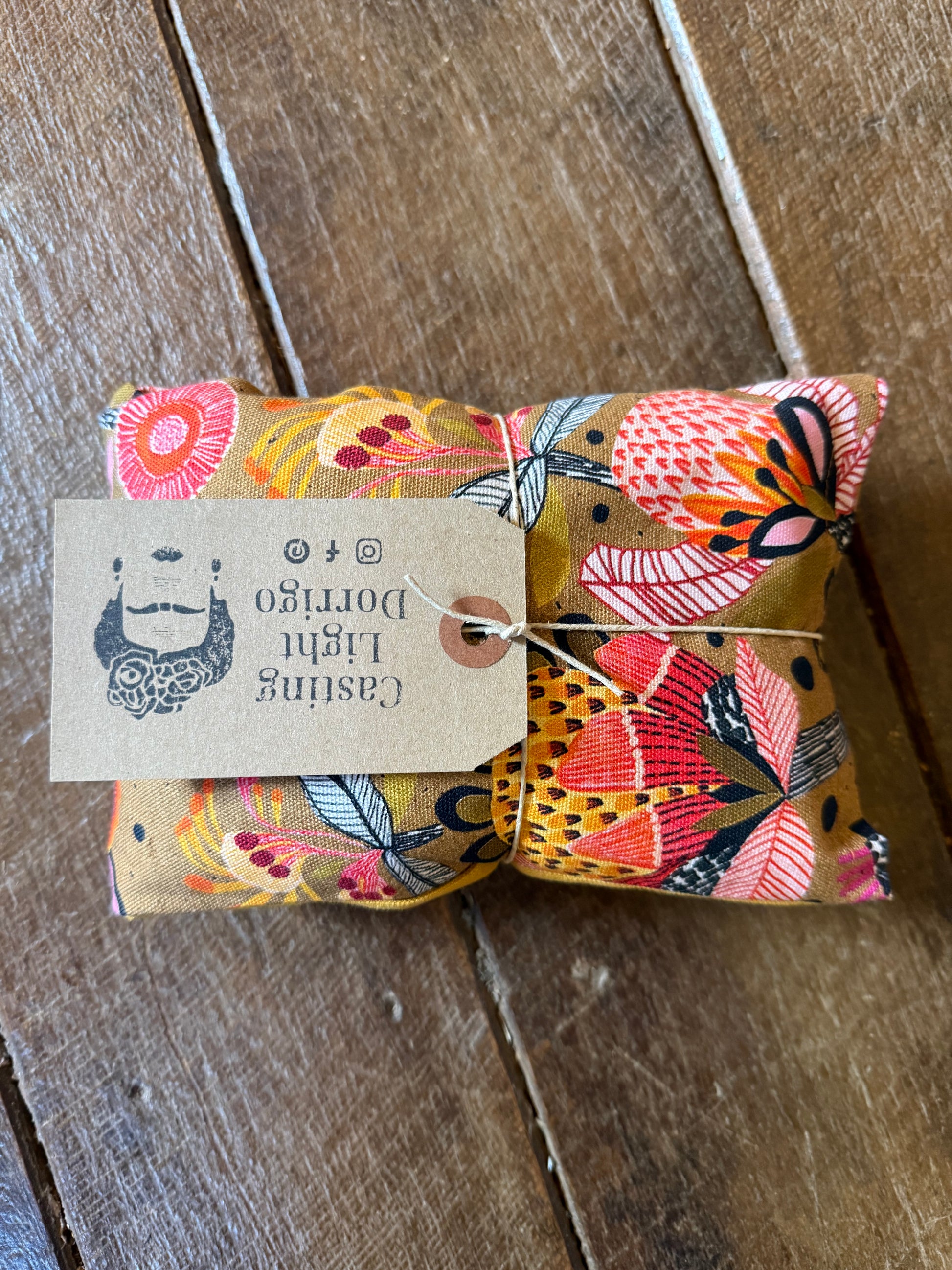 Small wrapped gift with a decorative tag on a wooden surface