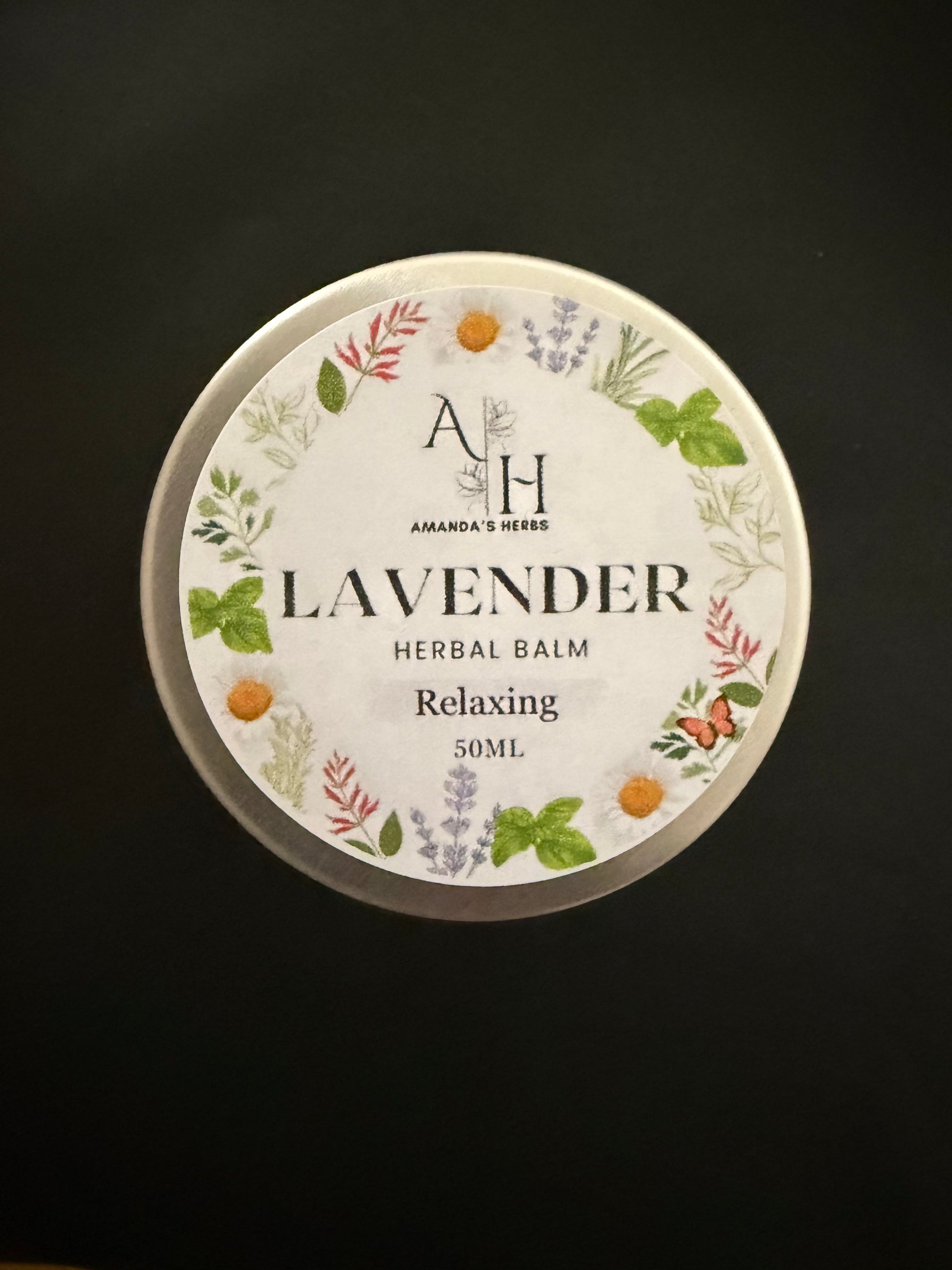 Lavender herbal balm container with decorative label on a black background