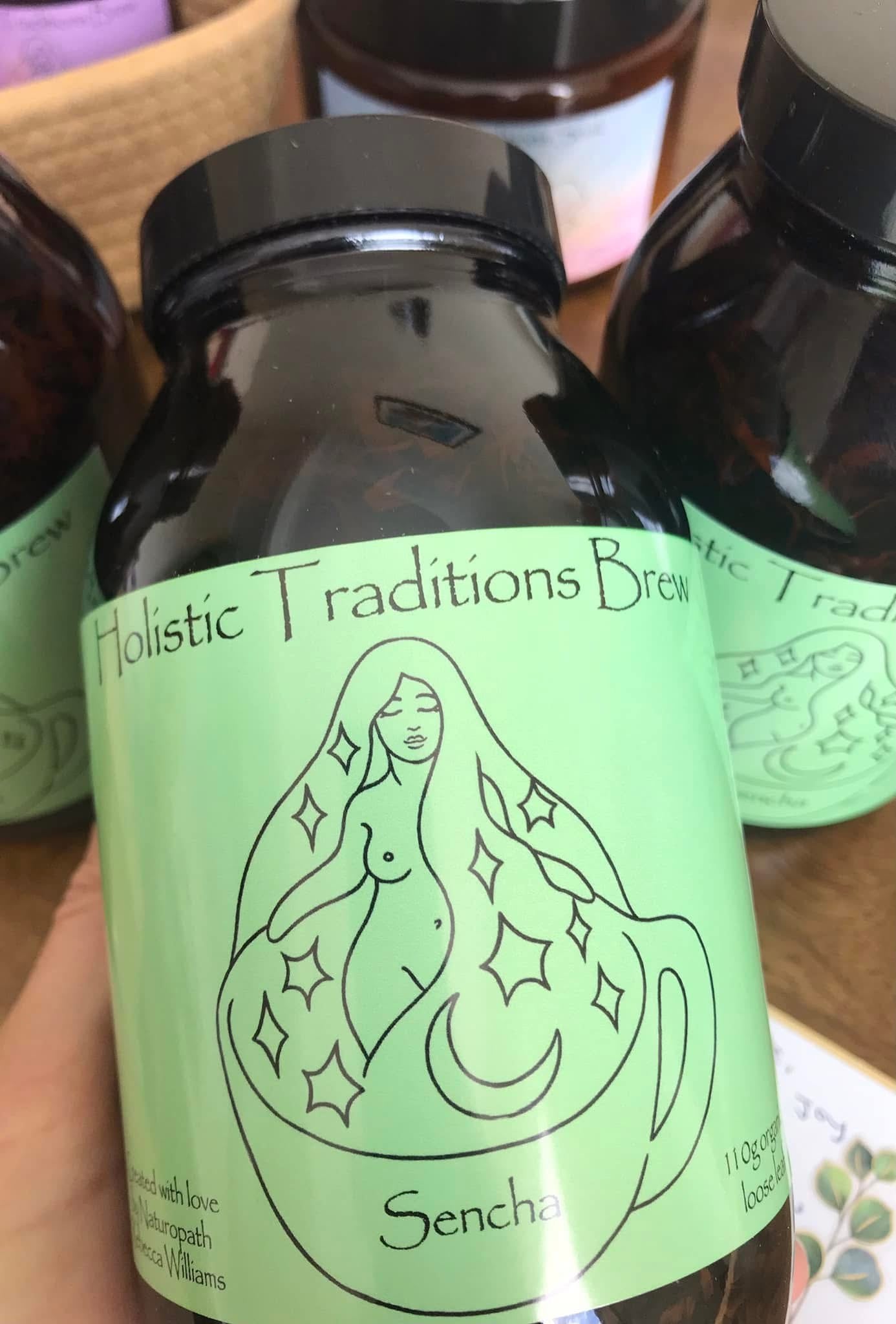 Bottle of 'Holistic Traditions Brew' with a green label featuring a woman's silhouette.